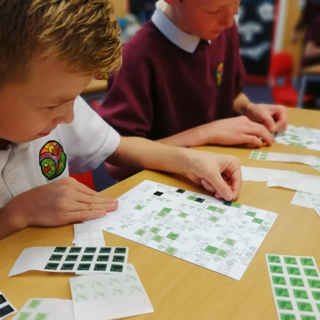 Two children sticking stickers onto card