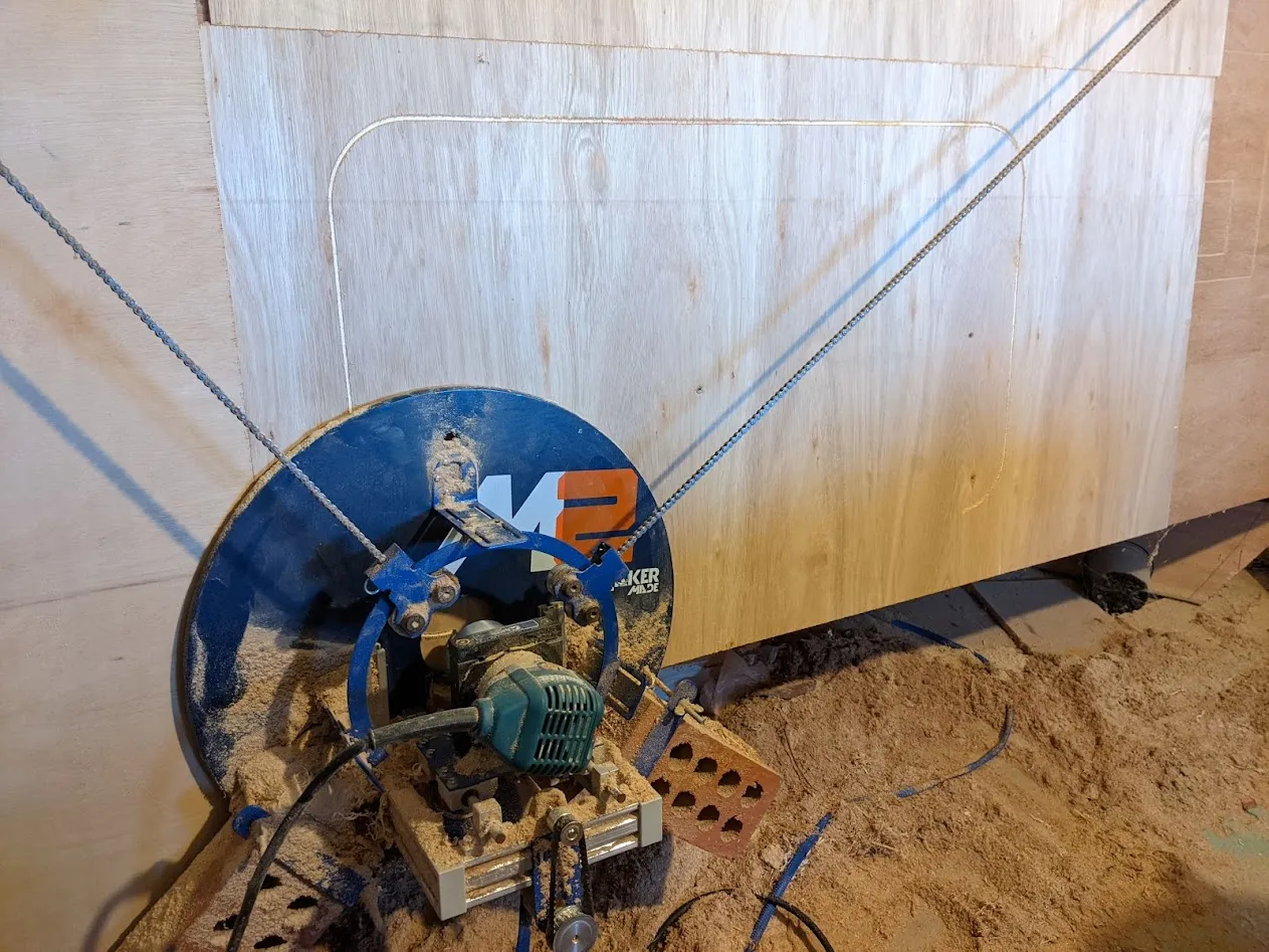 Machine hanging from chains against wood