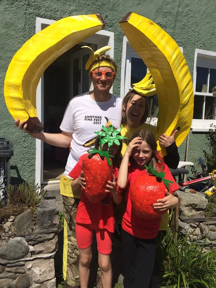 family holding bananas and strawberries