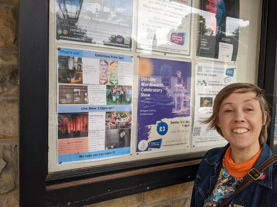 Woman head and shoulders in front of a notice board.