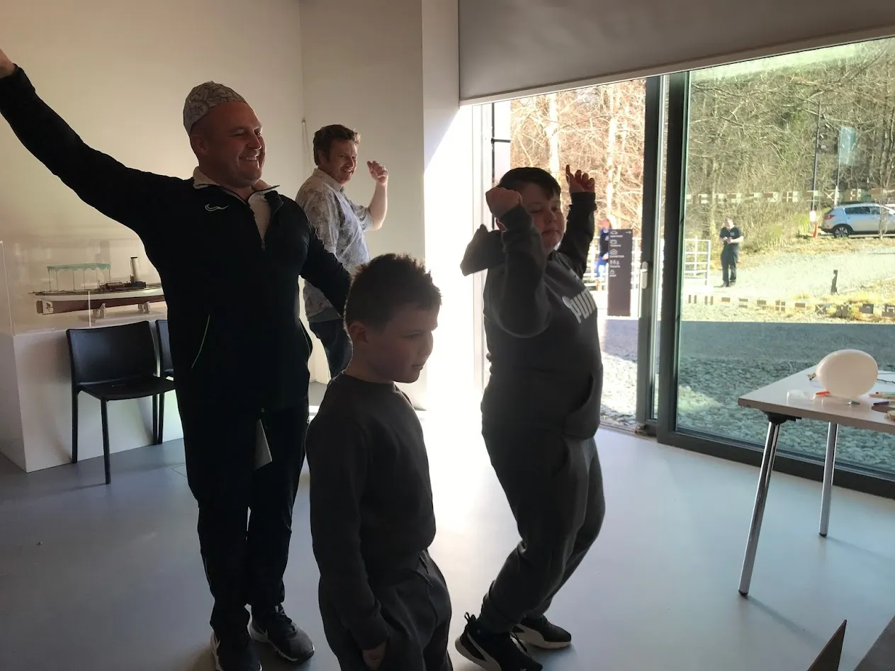 Man and two boys dancing with arms aloft!