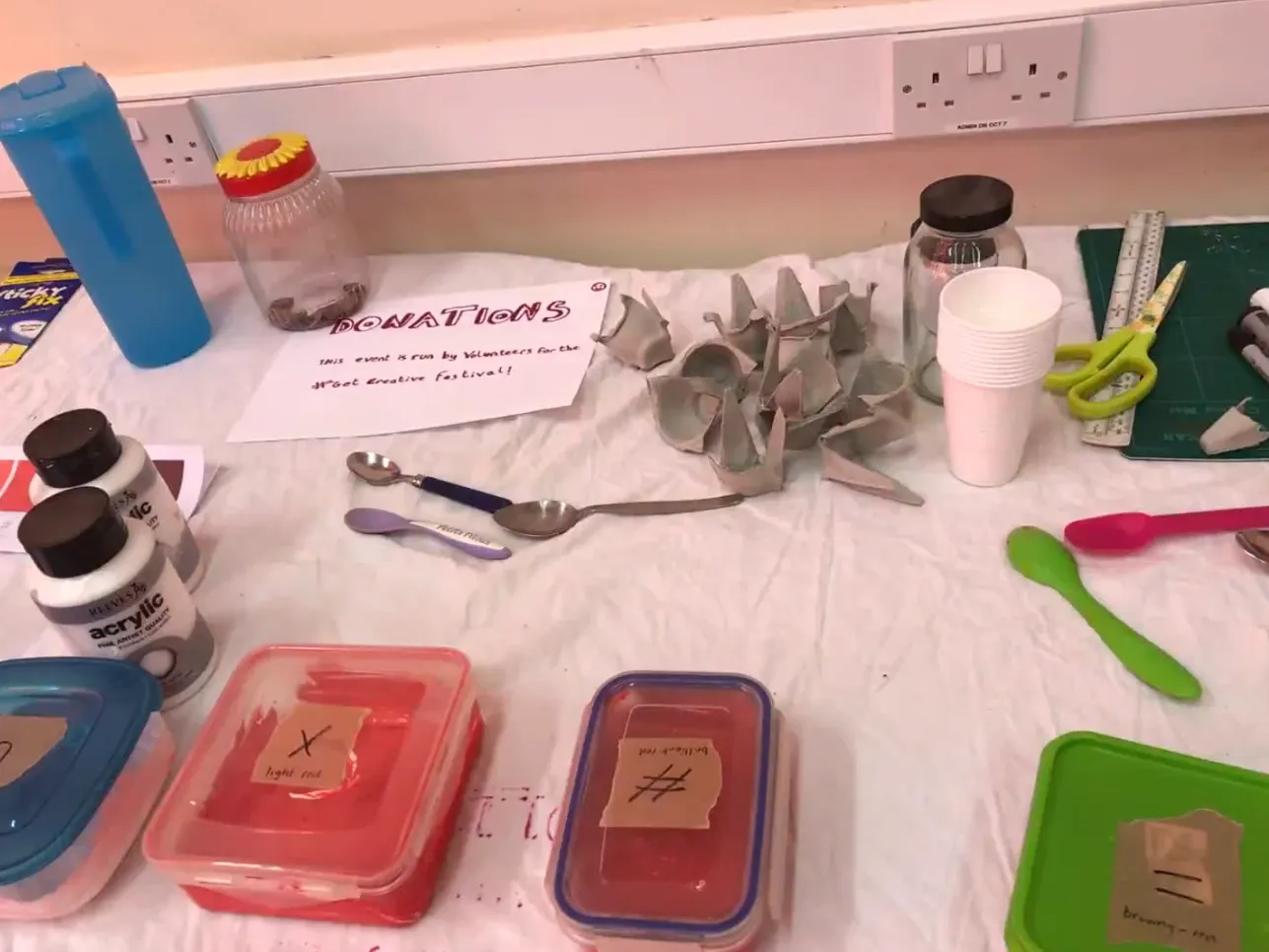 Paint pots on a table labelled with symbols.