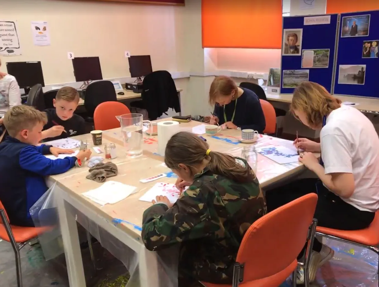People painting around a table.