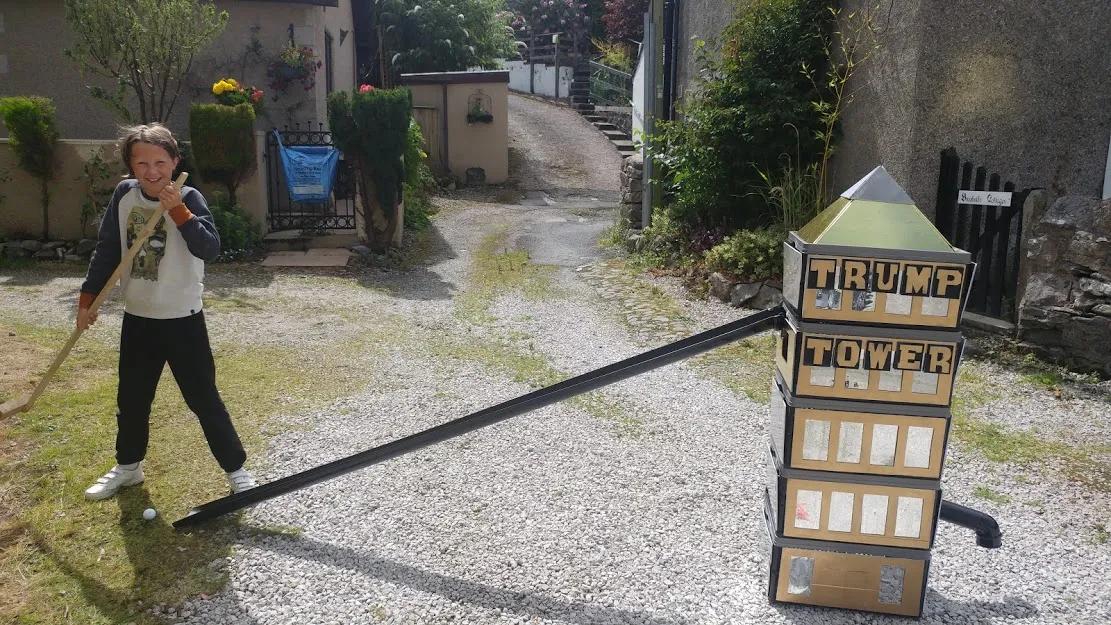 Girl about to hit golf ball into tower