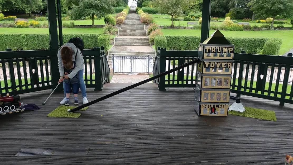 Mum helping child with golf club