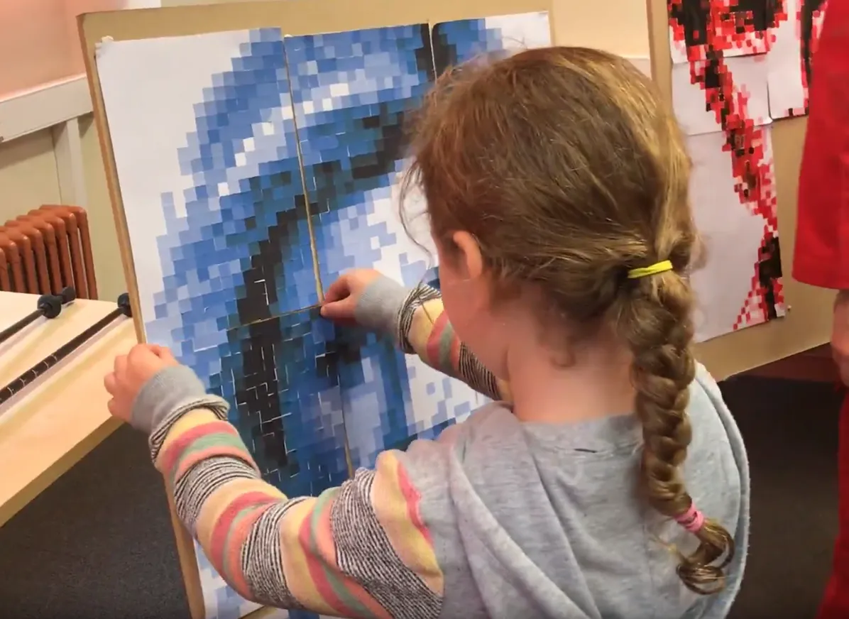 Girl adding sheet to picture.