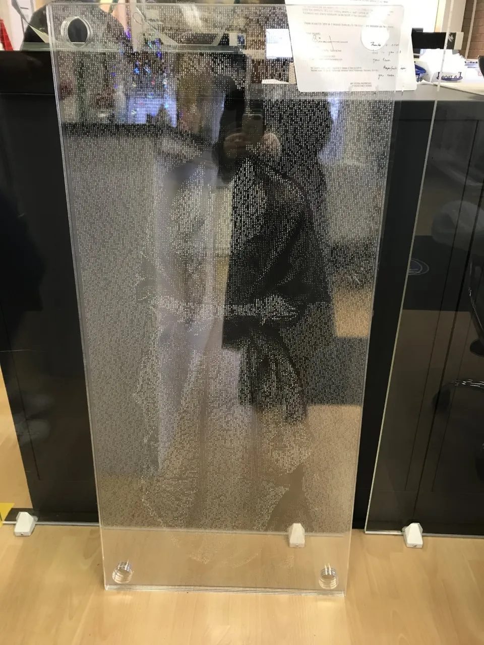 Woman's image seed faintly in clear perspex