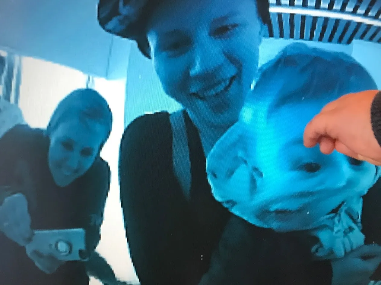 Distorted face of baby and mother in blue tinted screen