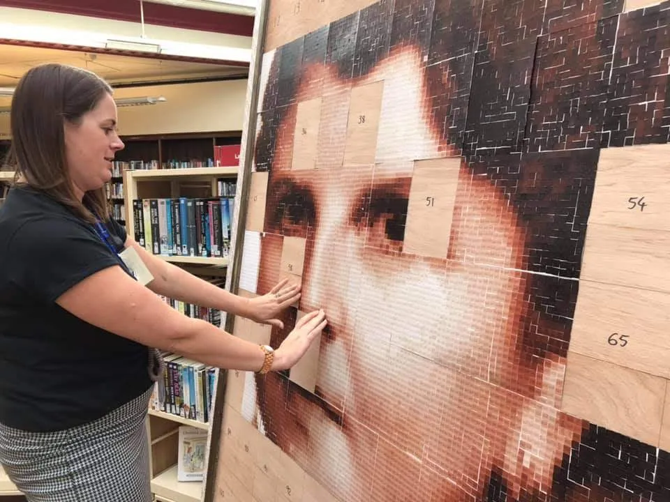 Librarian adding a finished card to the portrait.