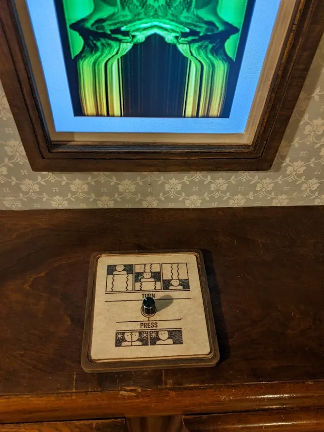 Dial mounted on a wooden board below a vertical screen with instructions to turn or
press.