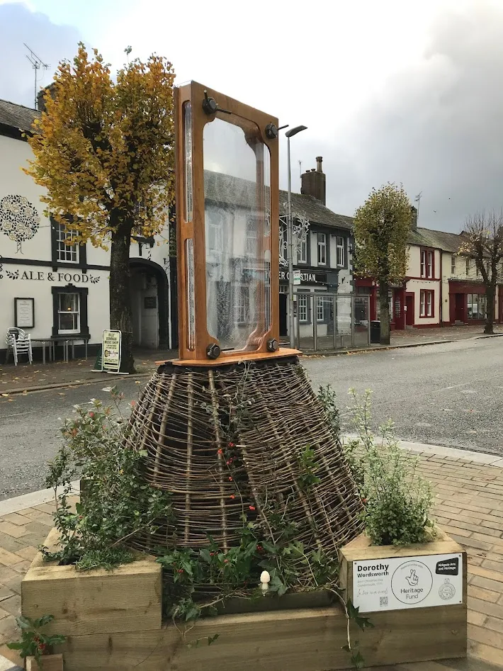 Sculpture in road with trees in the background.