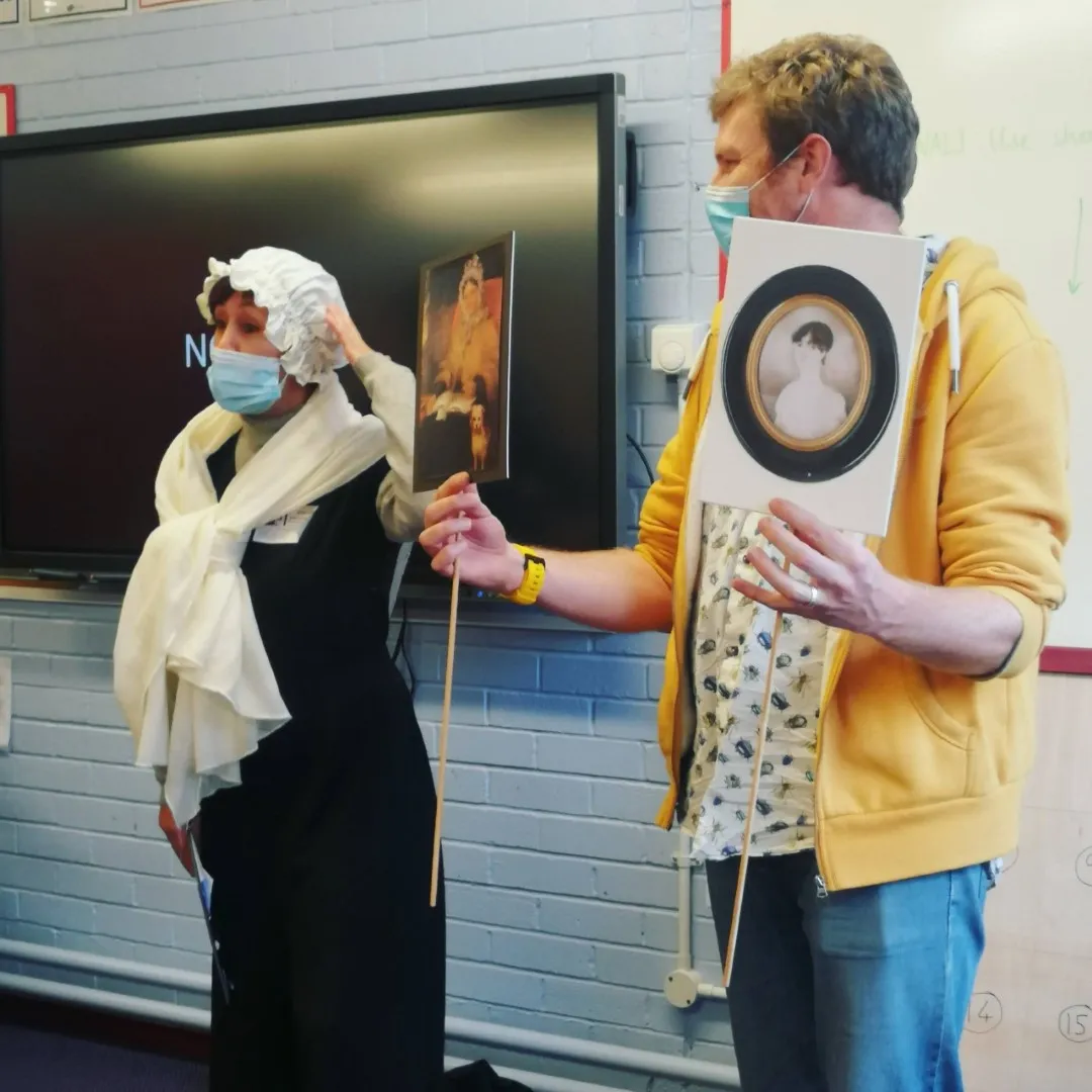 Jennie dressed as Dorothy and Chris holding up portraits of her