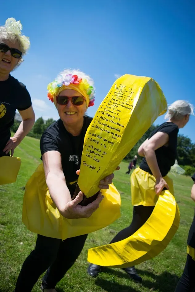 Woman holding giant banana with list written on it 