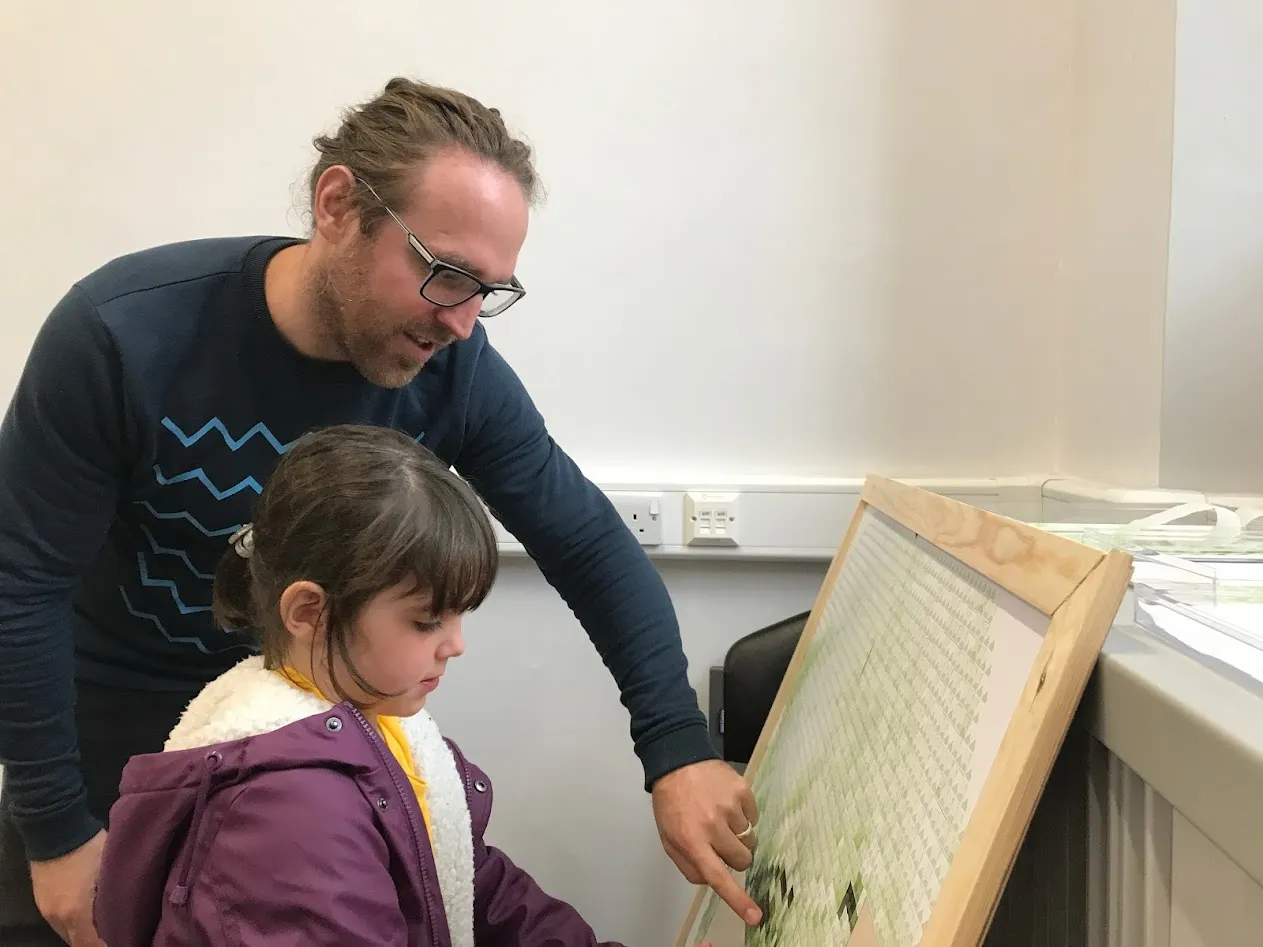 Girl putting card on a board held by a man