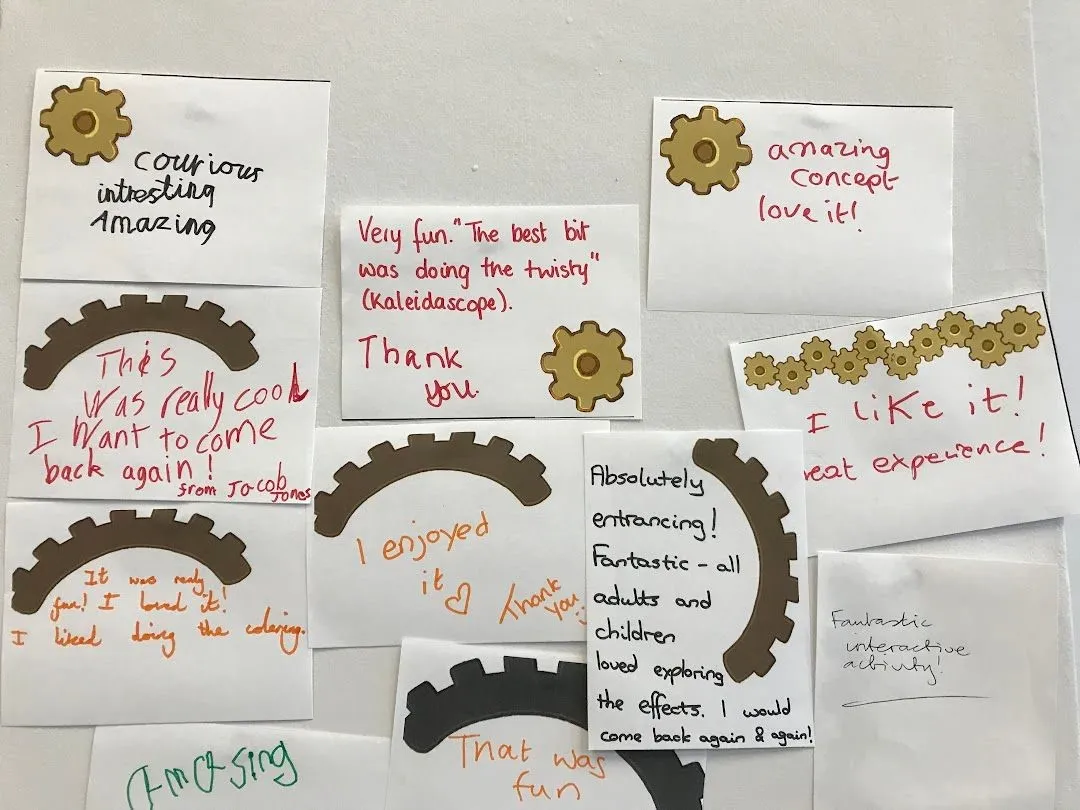 Paper notes on a wall with written feedback like: Curious, interesting, Amazing.  Absolutely entrancing!  Fantastic - all adults and children loved exploring the effects.  I would come back again and again.