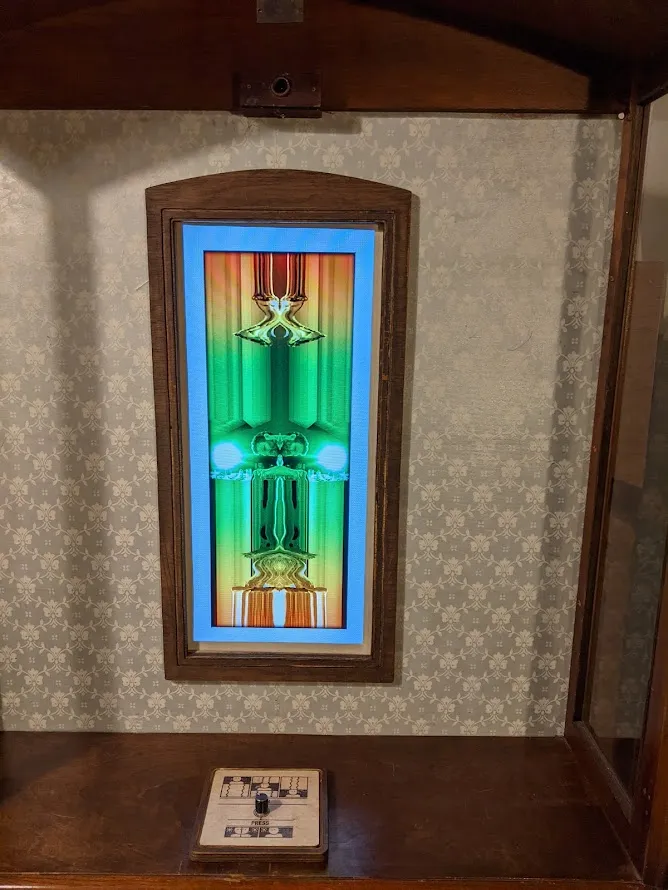 Vertical screen mounted on fleur-de-lis wall
paper.