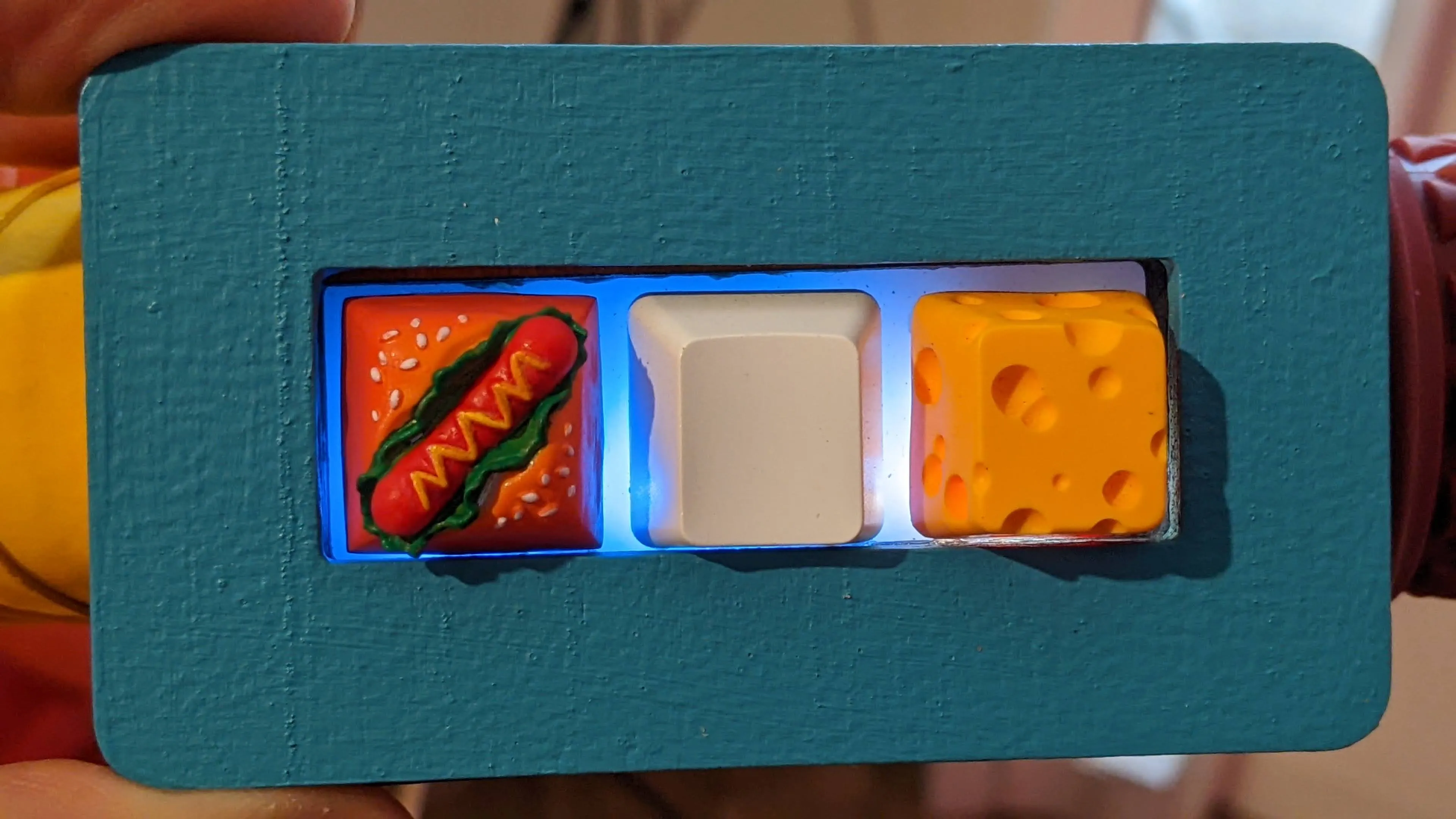 Three computer keys, the left one looks like a hotdog, the middle is white, the right one looks
like holey cheese