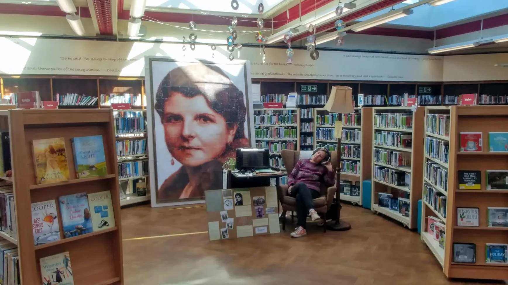 Woman listening to headphones in front of finished picture.