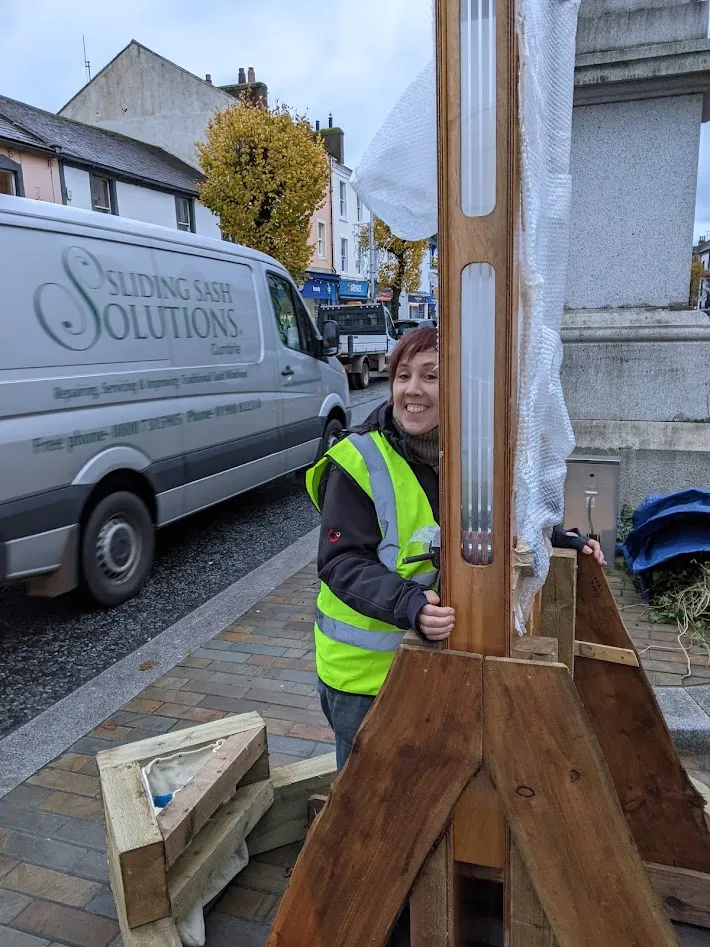Woman grasping large wooden structure
