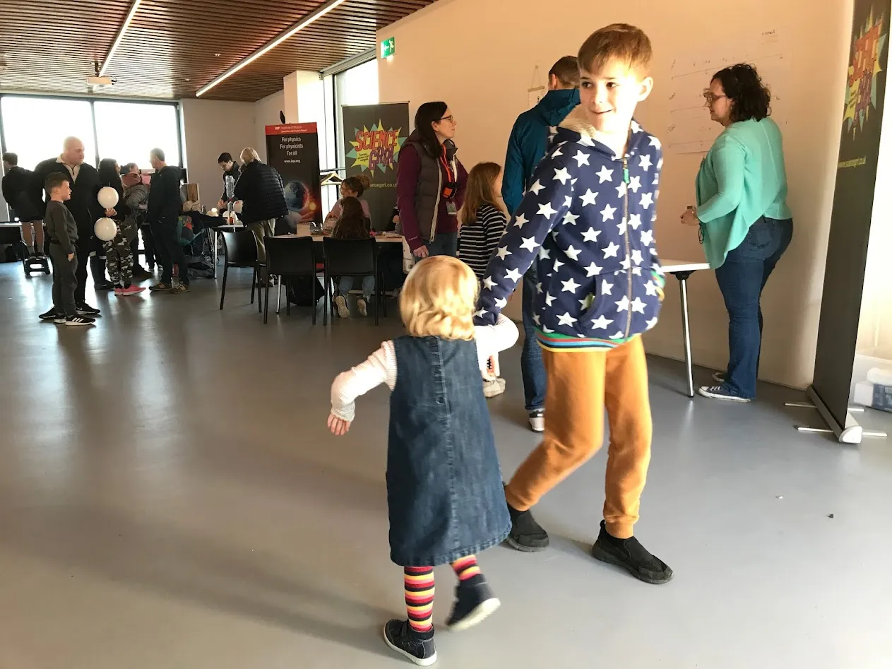 young girl turning arm in arm with older boy