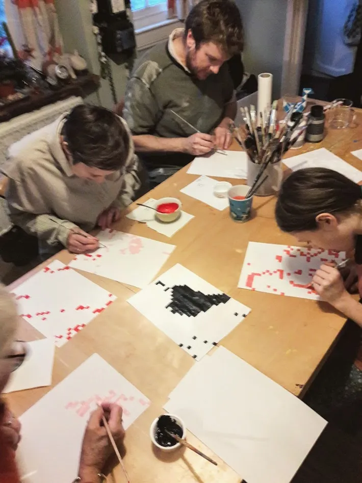People painting around a table.