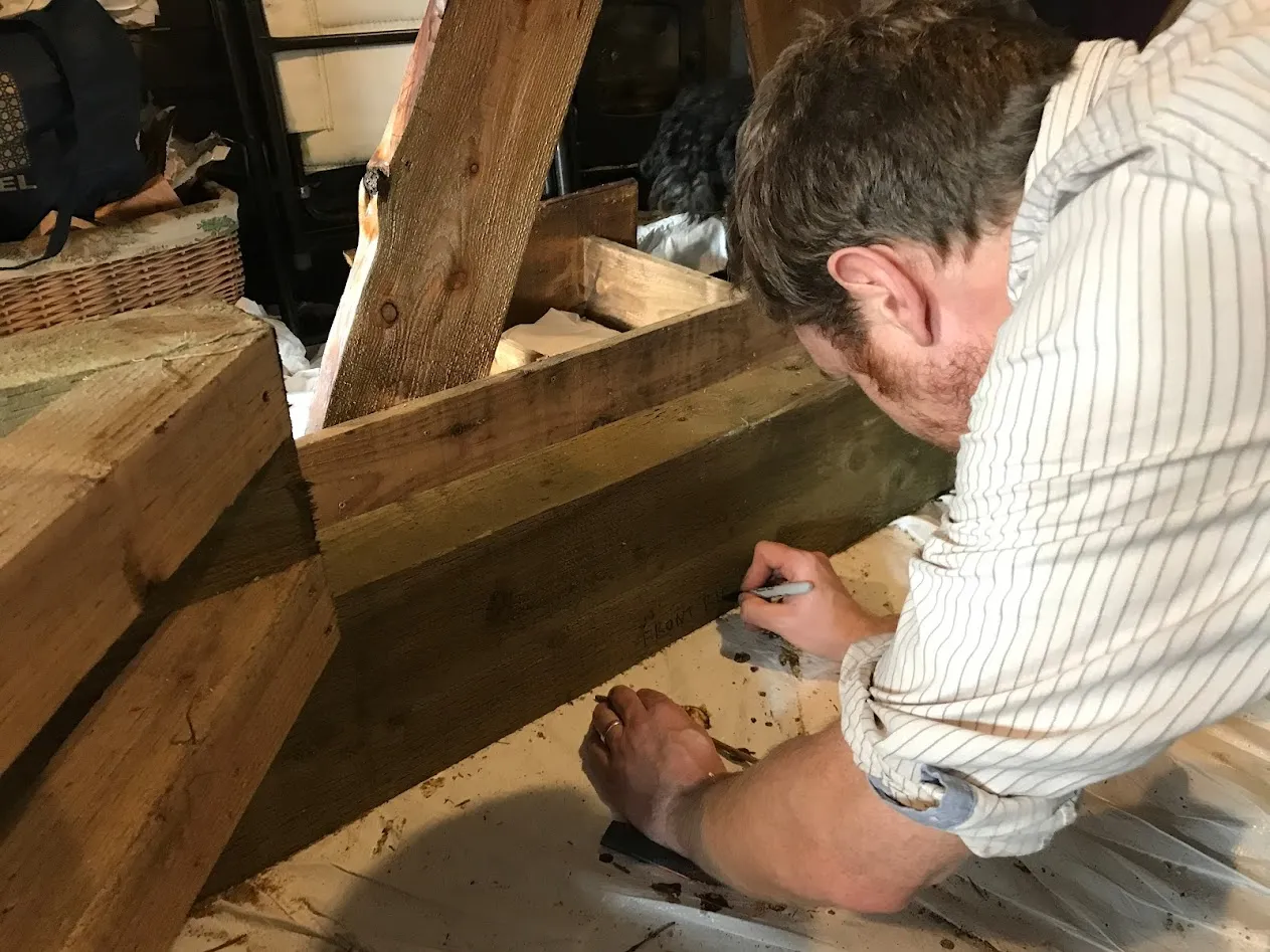man writing on block of wood