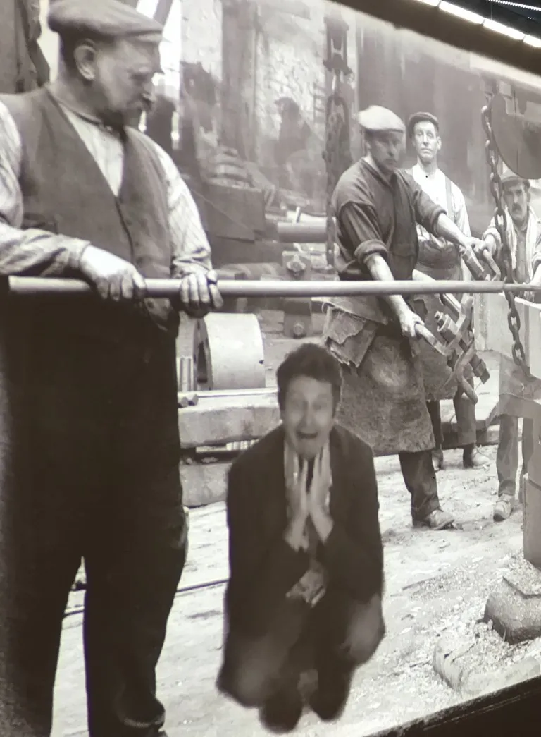 a ferry with 5 people standing on the ramp looking at the camera.