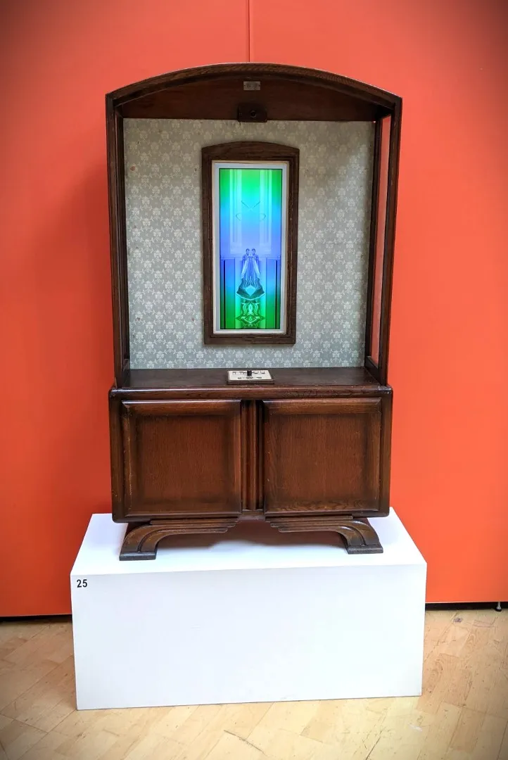 Cabinet on white block against an orange wall.