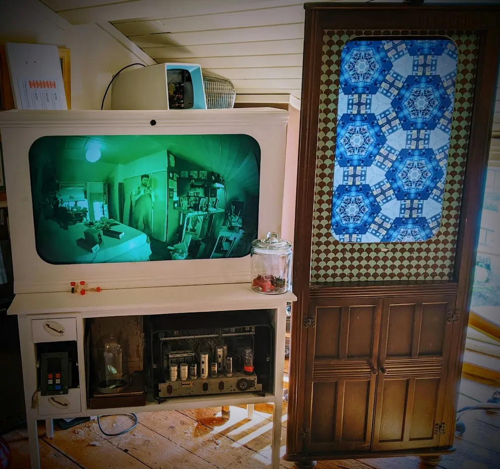 TV in white cabinet on the left, portrait tv in corner cabinet on the right.