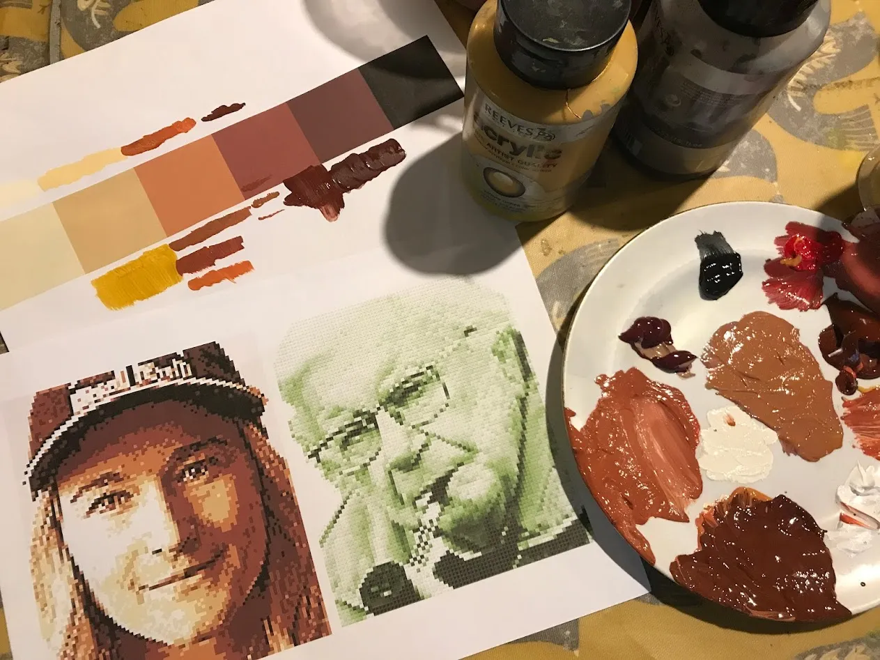 blobs of paint on a plate next to a printed palete and photos