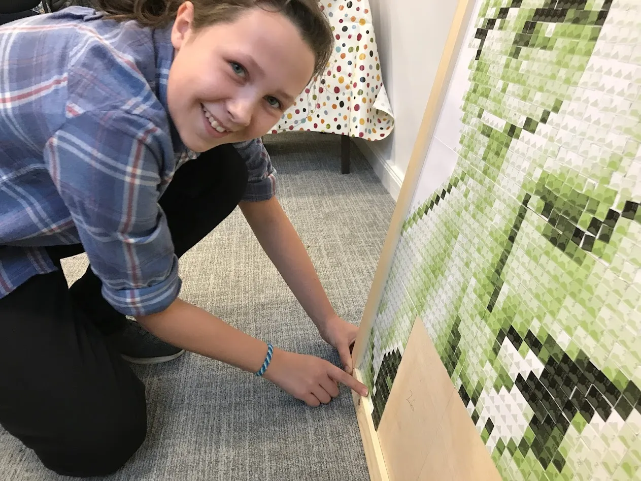 girl putting card on the bottom of a board