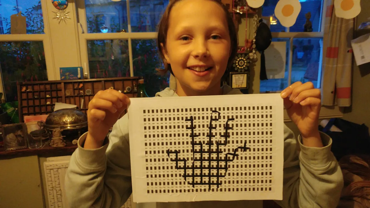 Girl holding up hand art made from stickers.