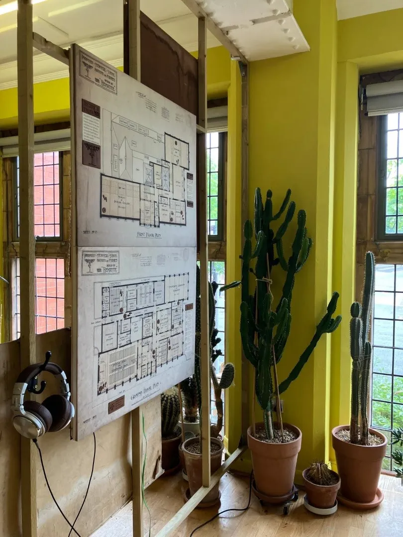 Large picture on wooden frames with cactus in the background.