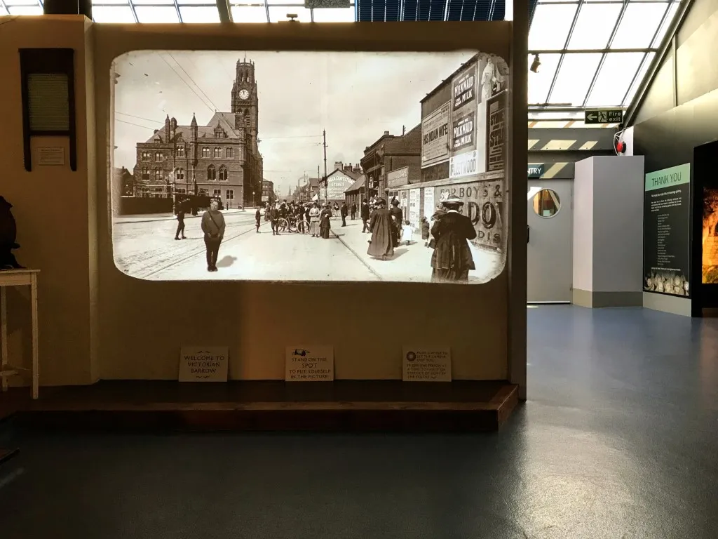 projected view of a victorian street with a clock tower and people walking
