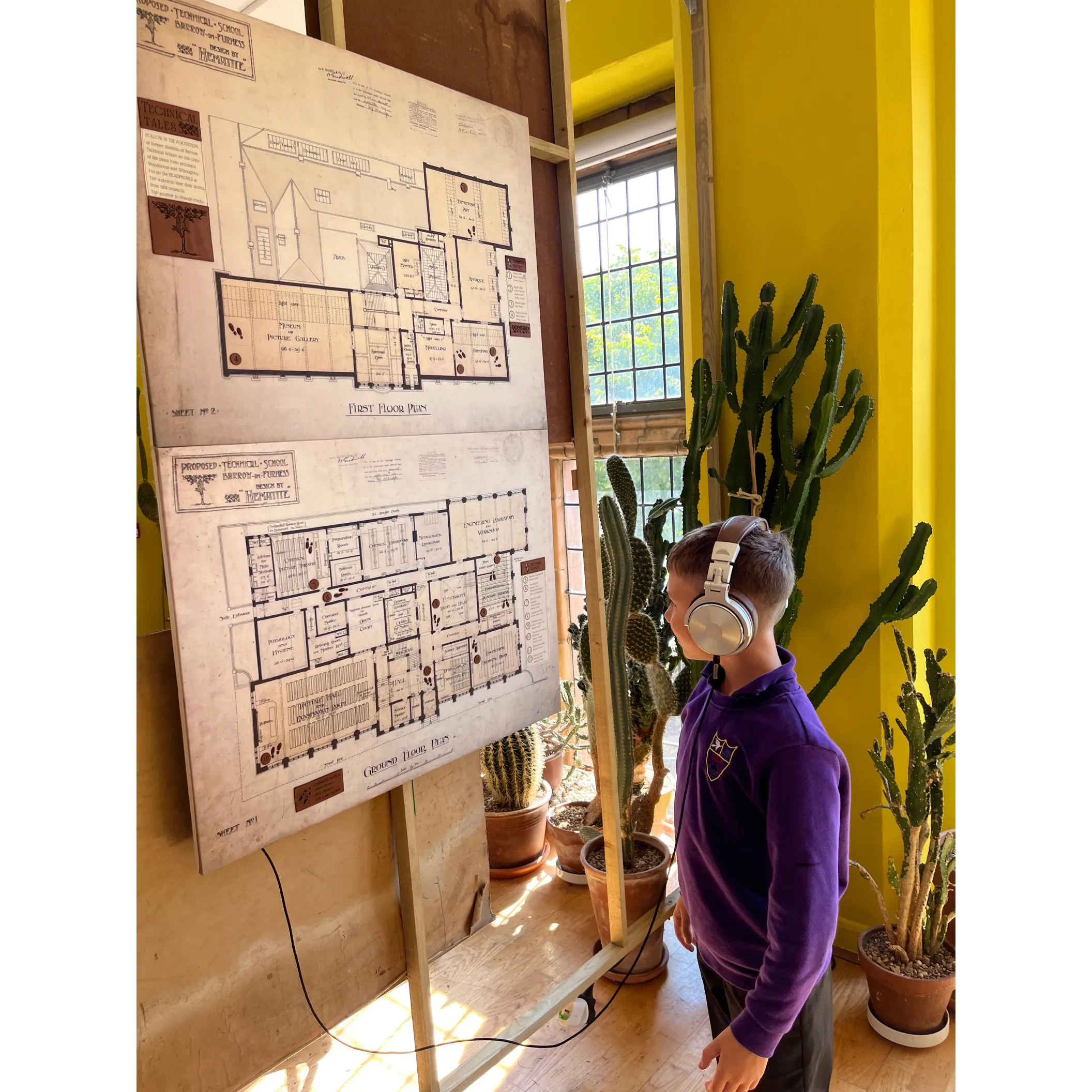 boy with headphones next to artwork