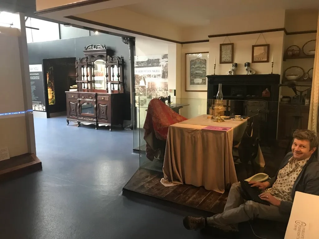 projected image of a victorian street with a clock tower and people walking