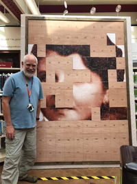 Man standing next to half completed image.