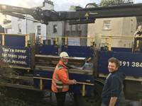 Two men standing next to truck containing sleepers