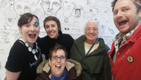 Five people in front of a doodle wall.
