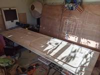 Wood on table in shed with machine hanging in background