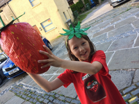 girl holding giant strawberry